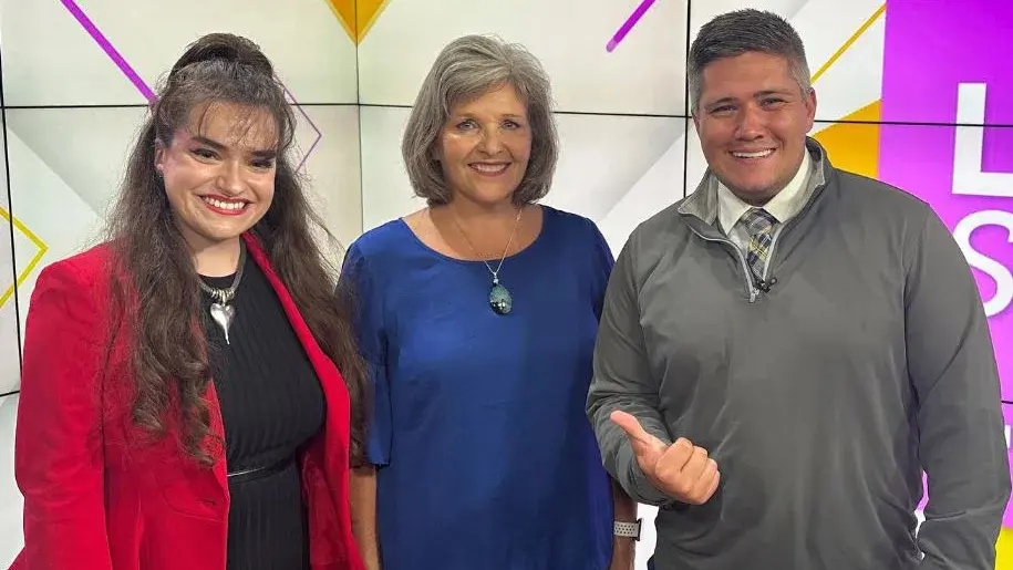 A close up of three people posing for the camera for WISH TV